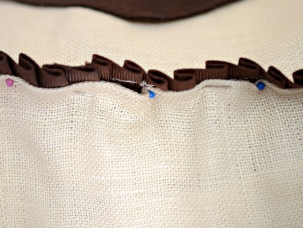 Sew around perimeter of pillow, following stitch line made when sewing on trim. Leave a 10 inch opening at bottom of pillow. Turn pillowcase right side out and insert pillow form. Carefully turn over raw edges, line up trim and pin opening together.