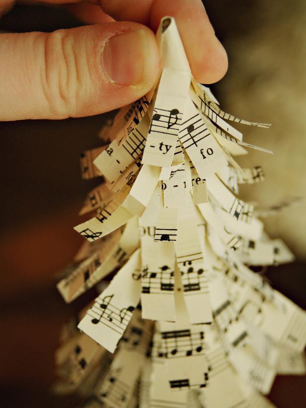 A small sheet music strip is glued to the top of a foam base to make a creative decorative Christmas tree.