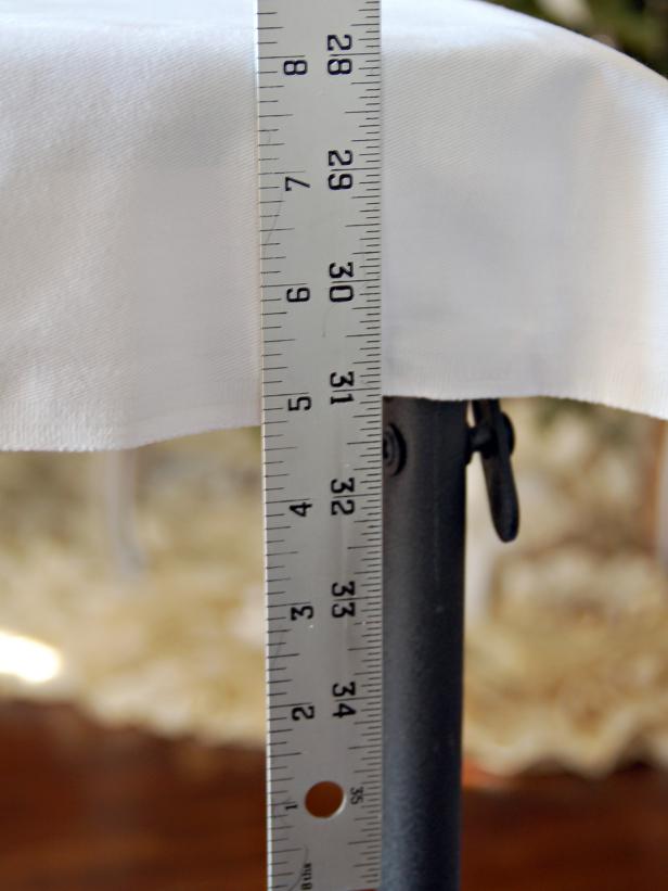 Use a yard stick to determine approximate drop length desired for skirt. (About seven inches is generally a good drop length.) For a seven-inch skirt, sew 15” squares of fabric together to create a piece long enough to wrap around table circumference twice.