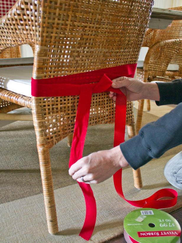Starting and ending at the back of the chair, wrap a ribbon around the back of each dining chair two times. Tie loosely in the center of the chair, leaving a long length of ribbon on both sides.