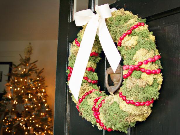 Cover a straw wreath form with moss and garlands of fresh cranberries for a colorful holiday decoration that can be used as either a traditional front door wreath or, laid flat on the table, as the base for a Christmas centerpiece. Learn how to make your own.
