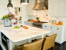 Transitional Kitchen With Large Island and White Marble Countertops