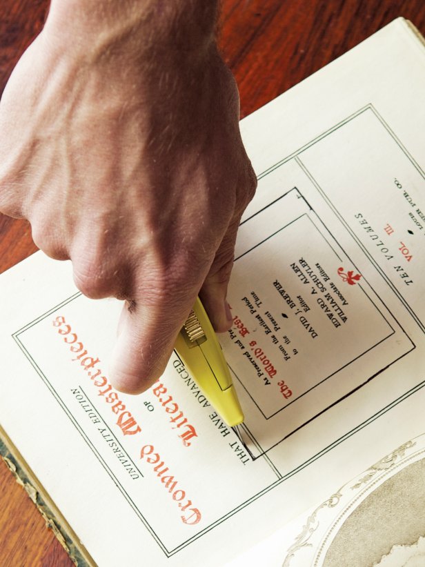 Cutting a box into pages of a book to make a vintage planter. 