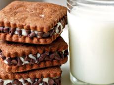 Brown Cookies With Creamy Filling, Chocolate Chips and Glass of Milk