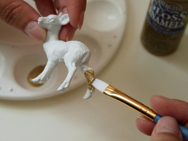 Once primer has dried, use a brush to coat deer's legs with gold paint.