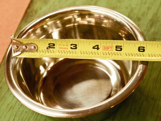 Measure the inside diameter of the bowls with a measuring tape, then determine their placement and spacing on the top surface of the box or other found object that was removed in the previous step.