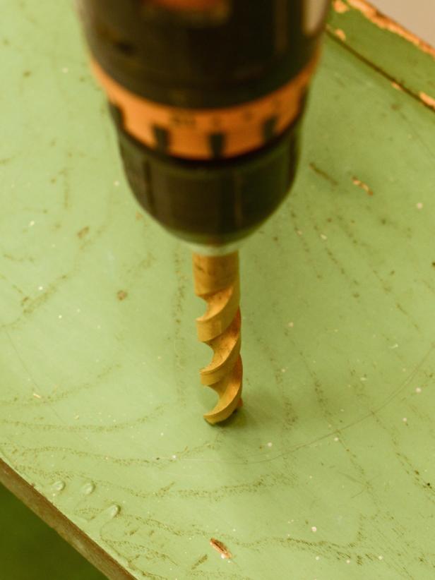 Using a drill with a 1/2-inch bit, drill a hole just inside one of the marked circles.