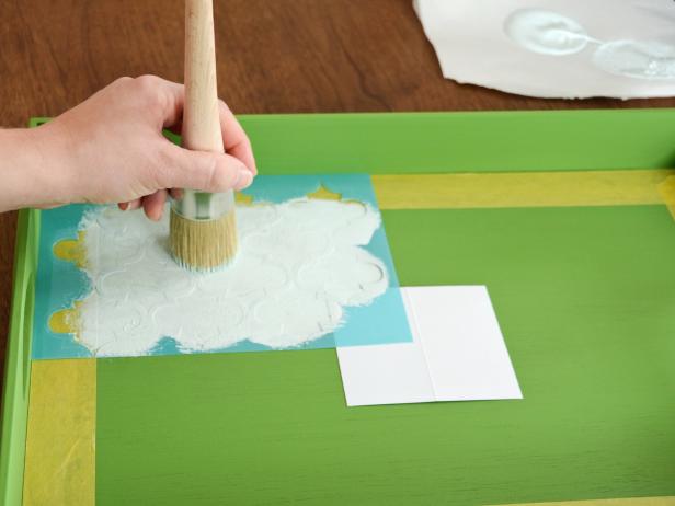 Place stencil in top corner of tray and apply paint with a stencil brush using a straight up-and-down pouncing action. Tip: Don't overload the brush with paint, and wipe off excess to prevent bleeding under the stencil.