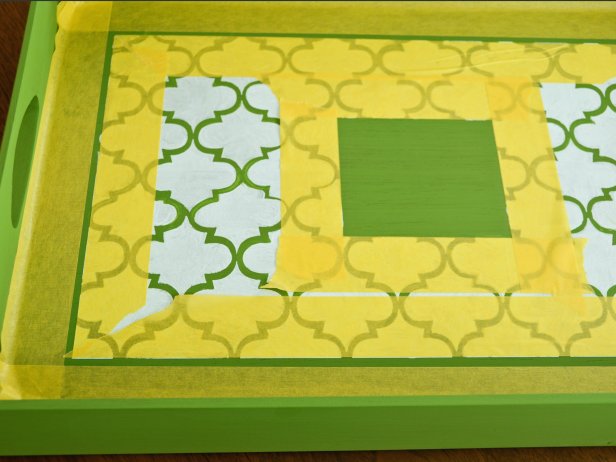 Allow stenciled design to fully dry, preferably overnight. Tape off a 1/4-inch stripe around the stenciled design and the center box.