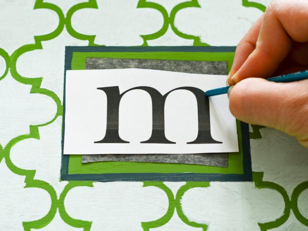Using a word processing program on your computer, design a monogram. It can be a single letter or three initials. Tweak the font size until the printed design will fit in the monogram box on tray. Print then cut out the chosen letter or letters. Also cut graphite transfer paper to approximately the size of the monogram. Place monogram on top of graphite transfer paper with the dark side facing down. Check that monogram is centered in the box then trace lettering with a pencil or the back side of paintbrush handle.