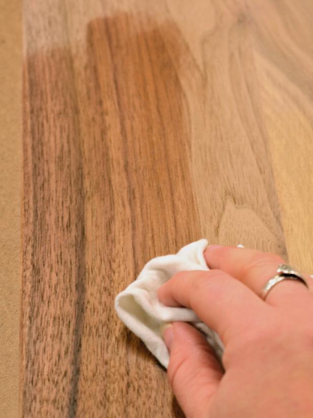 Once glue has dried, remove the cutting board from clamps. Scrape off any excess dried glue gently with a chisel. Using an orbital sander fitted with an 80-grit sanding pad, sand both sides of the board and edges to soften corners. Repeat sanding process with 120-grit, then 220-grit sandpaper. Make sure all dried glue is sanded off surface prior to finishing. Rub entire cutting board with several coats of a food-safe finish like mineral oil, walnut oil or beeswax, allowing oil to fully absorb into the wood. Allow cutting board to dry overnight before use. Tip: Most food-safe finishes need to be reapplied regularly. If giving this board as a gift, also present the recipient with a bottle of oil as a companion gift along with care instructions.