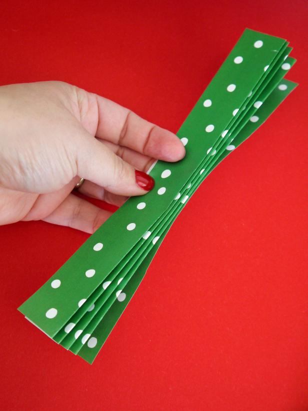 Fold a 8-1/2 by 11 inch piece of paper into an accordion with 1-inch folds. Repeat twice to get three folded rectangles of paper.