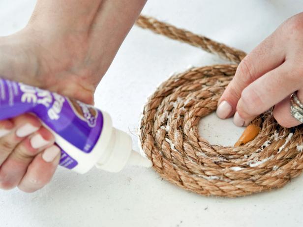 To create the basket's base, apply glue along the first 5 inches of the rope. Coil the rope on a flat surface, applying more glue on every inch of the rope. Keep coiling and adding more rope until you have the circumference of basket you prefer.