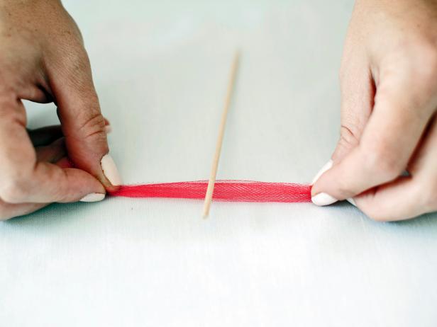 Cut the tulle into 1-inch strips. Tie the strips around the top of plain, wooden stirrers.