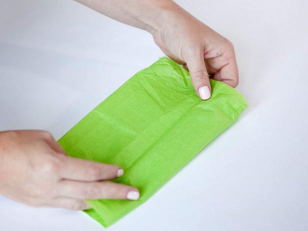 Fold tissue paper 4 times to create a beautiful and simple box for gift wrapping.
