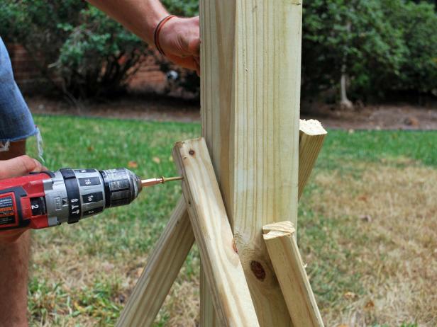 Drilling Stakes Into Pine Post for Outdoor Holiday Tree