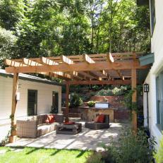 Outdoor Living Room With a Pergola and Grilling Station