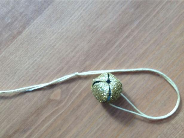 Run string through glitter bell and tie ends together.