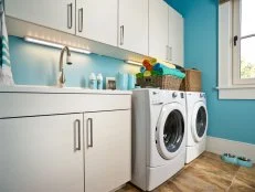 Blue Laundry Room With White Washer and Dryer and White Cabinetry
