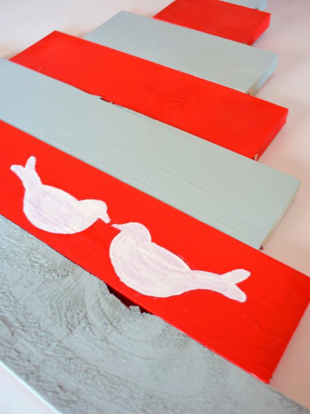 Find a dove stencil online by searching Google for “dove template.” Print and cut out a template. Place on top of your bottom board and spray carefully with white paint. Peel back the template to reveal the doves.