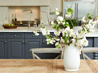 Kitchen With Pewter Blue Cabinets & Flowers in Vase on Wood Table