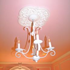 Pink Girl's Nursery With White Metal Chandelier