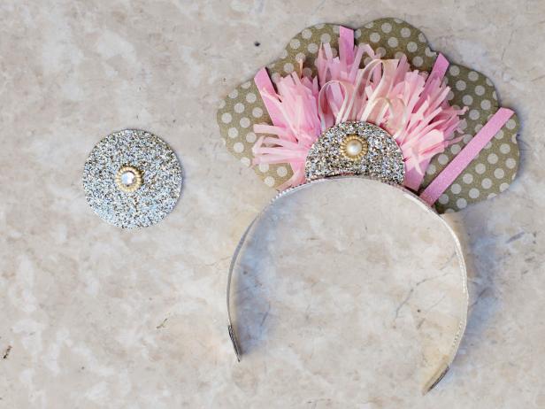 Using a 2-inch circle punch or scissors, cut circles of glittered cardstock to embellish the tiara. Add sections of fringed tissue paper and a button or brad. Attach all embellishments using hot glue.Let guests keep their headbands as a fun New Year's Eve party favor.