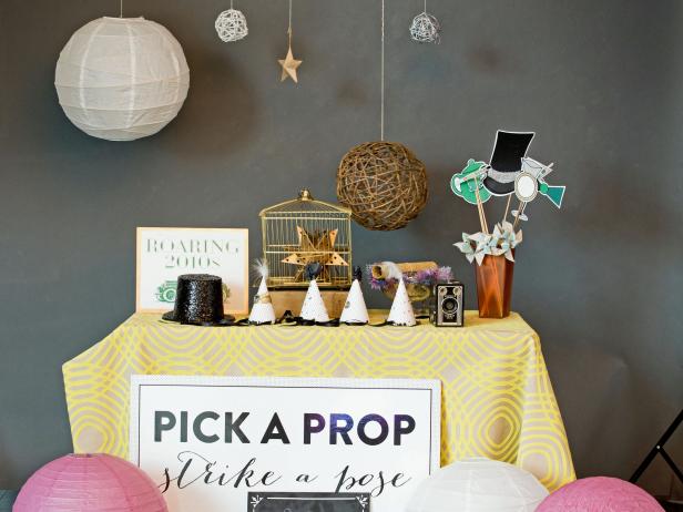 Assemble a prop station and display items guests can grab easily to pose with. A practical way to decorate the prop table without adding unnecessary items to the surface is to hang objects from the ceiling using twine and push pins. Make a simple signboard instructing guests to pick a prop and strike a pose and place it near the prop table.