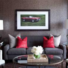 A Framed Picture of a Muscle Car Centers a Gray and Red Living Room