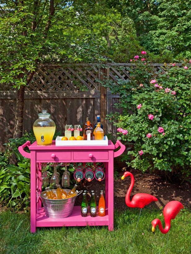 Outdoor Space With Stocked Pink Bar Cart and Yard Flamingos