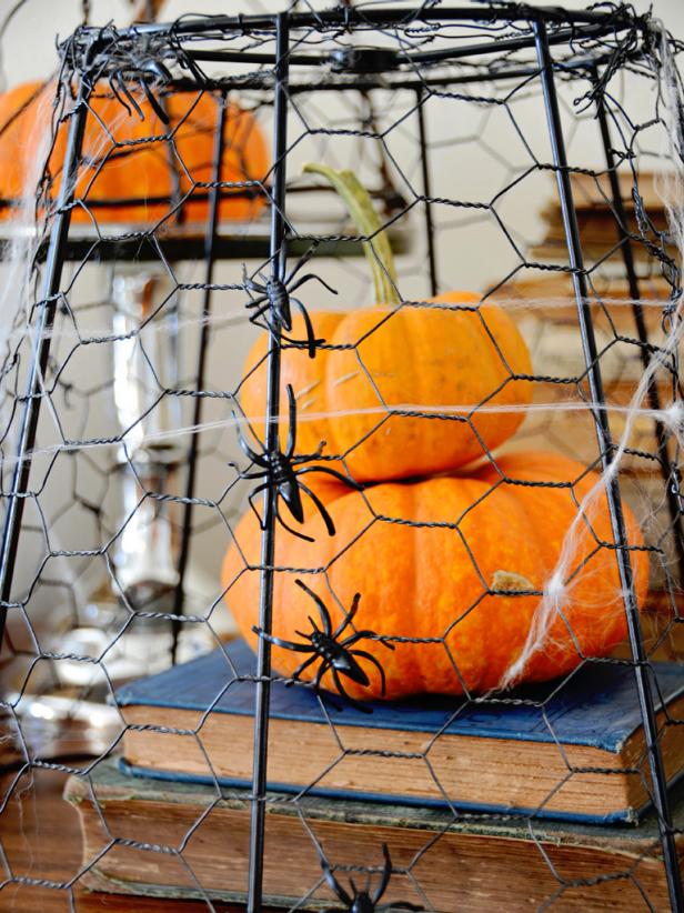 Repurposed chicken wire creates a cage around pumpkins and a place for spiders to climb.