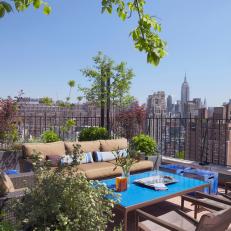 Urban Rooftop Patio With Bold Blue Table and Iron Railing