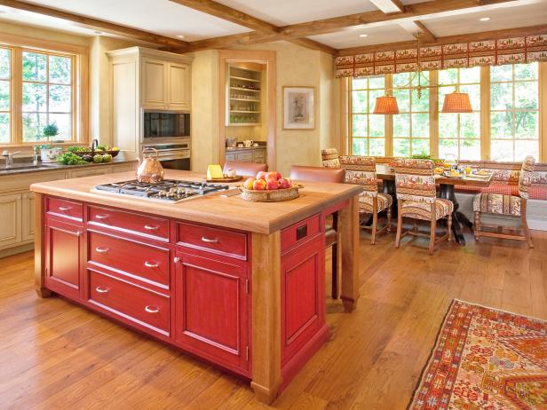 Yellow Country Kitchen With Beamed Ceiling and Red Island 