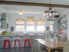 White Cottage Kitchen With Red Barstools and Large Hanging Lantern