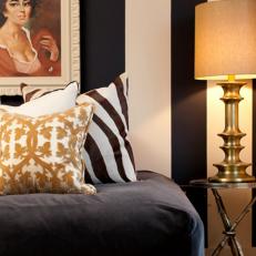 Guest Bedroom With Neutral and Gold Pillows and a Bronze Lamp