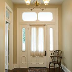 Traditional Entryway With Cream Walls, Wood Floor and Chandelier