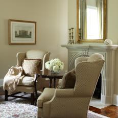 Traditional Living Room With Matched Wingback Chairs and Gold-Framed Mirror
