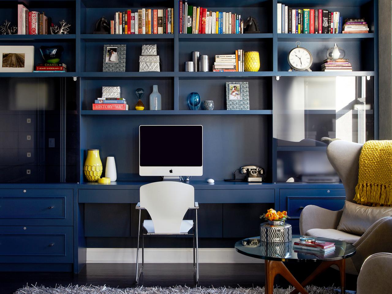 Contemporary Home Office With Navy Bookshelves And Yellow Accents