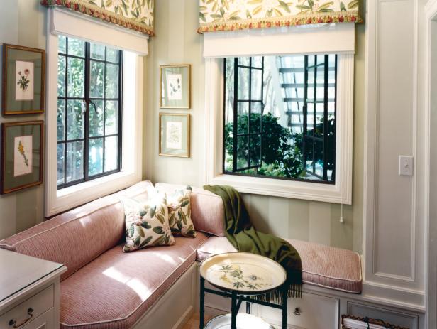 Corner Banquette Against Green Striped Walls With Botanical Prints
