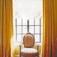 Gold Flowing Drapes in Front of a Large Pane of Old -Style Windows