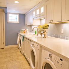 Spacious Blue Transitional Laundry Room With White Cabinets