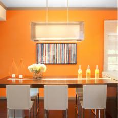 Bright Orange Dining Room With Modern Pendant Light