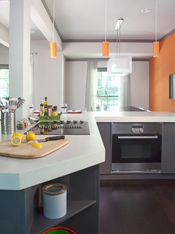 White Kitchen With Gray Cabinets and Orange Pendant Lights