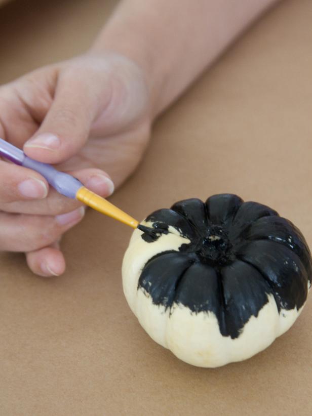 Woman painting miniature pumpkins