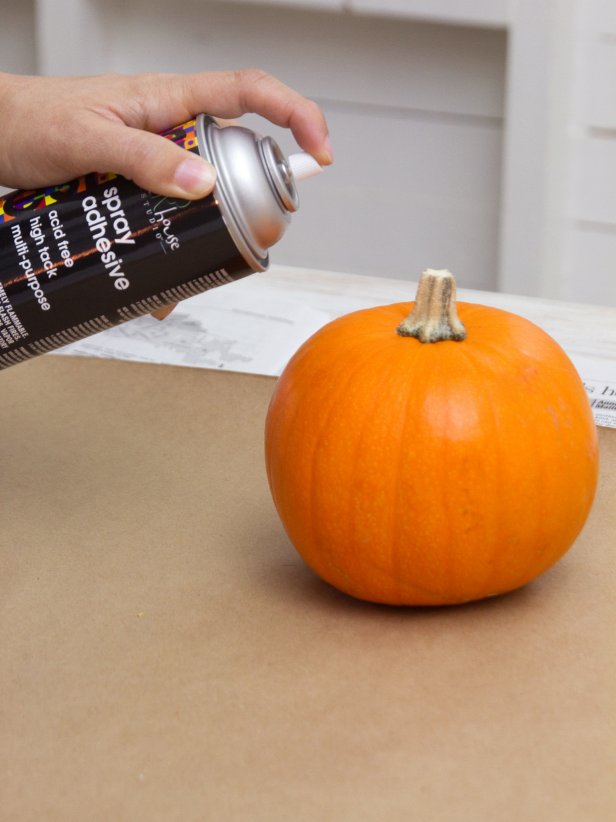 Spray the top and middle portion of a pumpkin with spray adhesive. Tip: Unless you want to glitter the stem, try not to spray it with adhesive. Cover it with painter's tape if necessary.