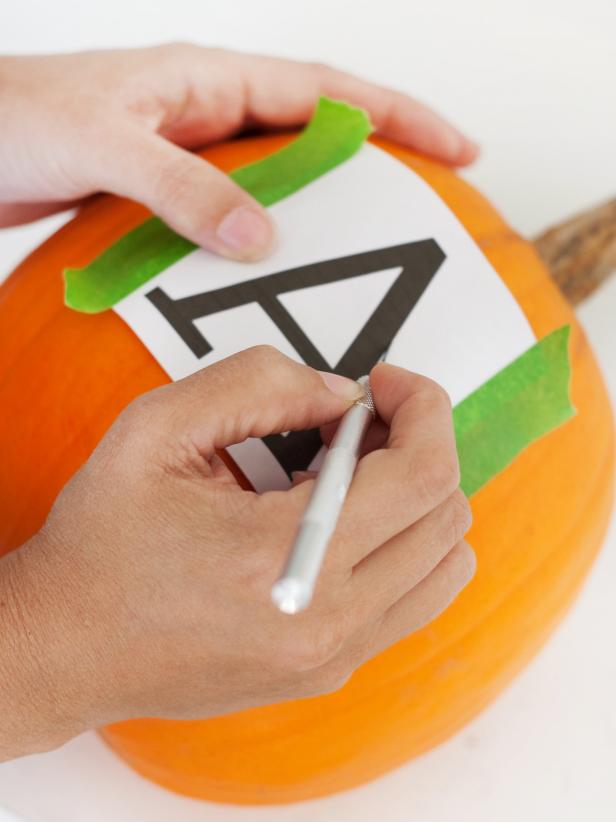 Using an exacto knife, trace the letter's outline onto the pumpkin. Tip: If the letter has any inside lines, cut those out first. Use a napkin or paper towel to wipe off any juice that may have seeped out during the tracing process.
