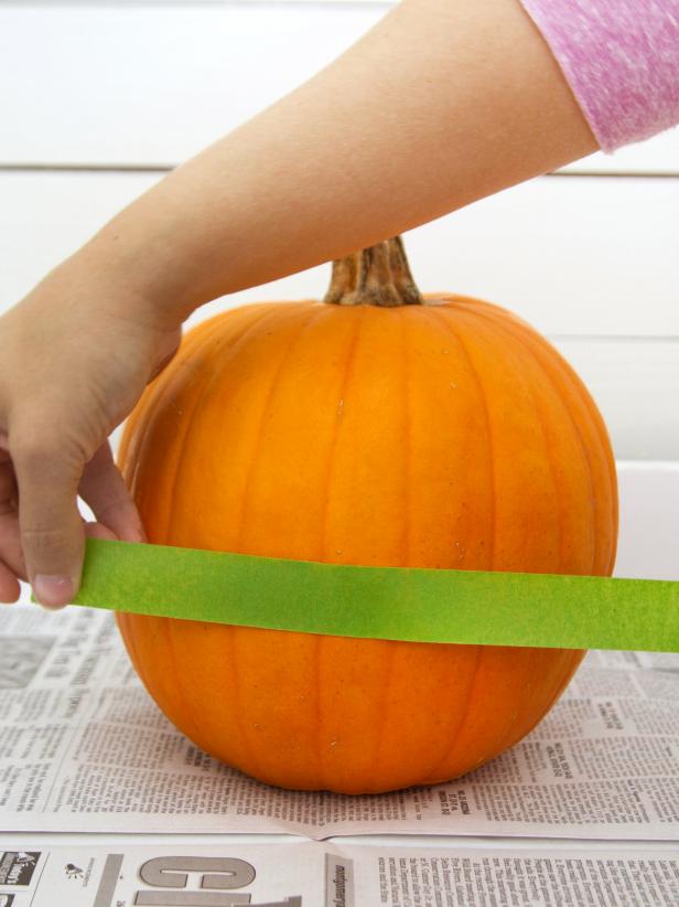 Attach a piece of painter's tape around the center of the pumpkin.