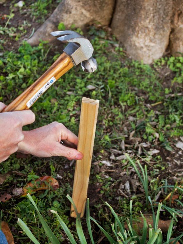 Man hammering stake into ground