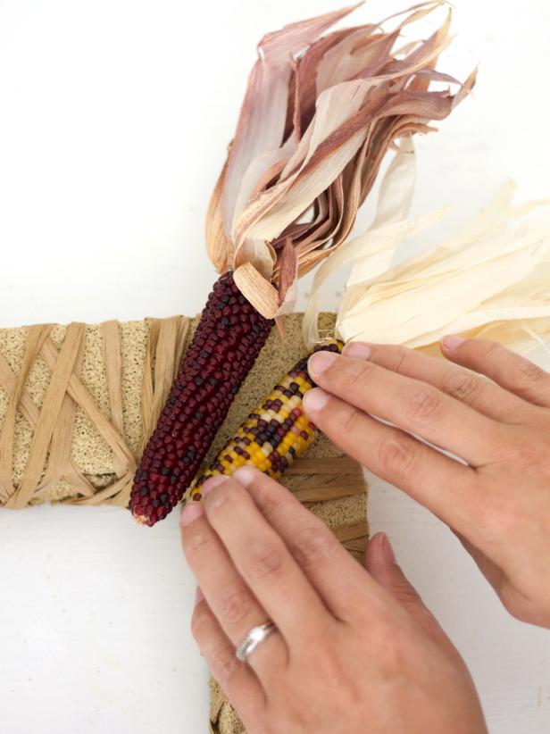 Attach two ears of Indian corn to each corner of the wreath with hot glue.
