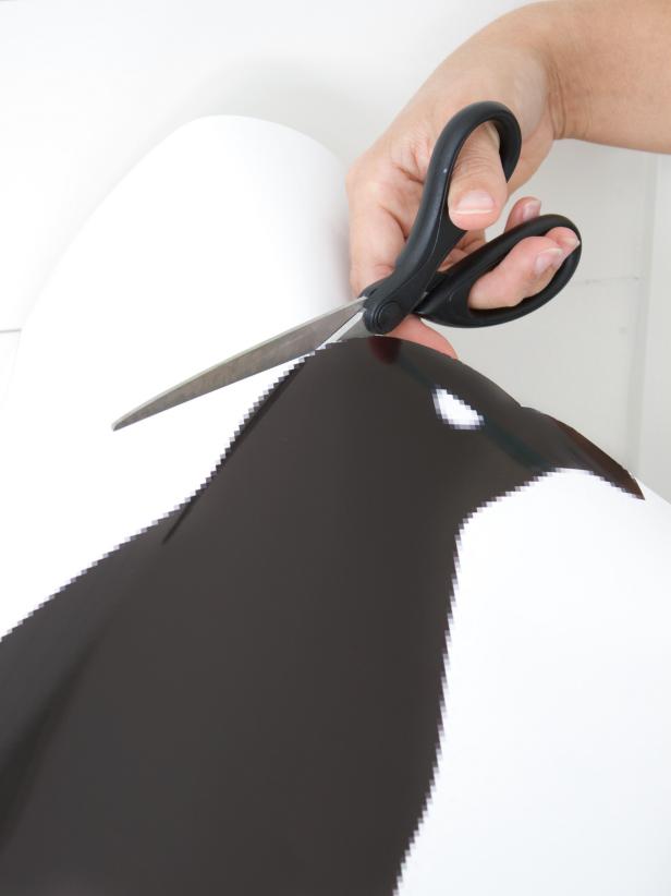 Using scissors to cut out raven template